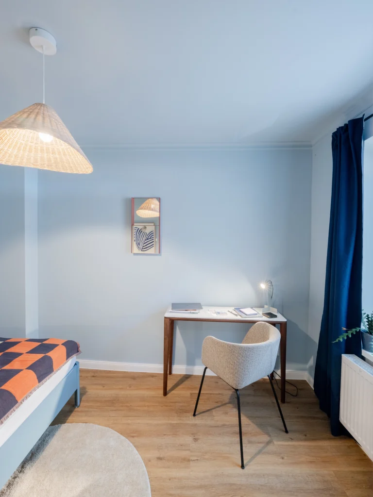 Kleines Schlafzimmer in einem Hamburger Apartment mit Farbkonzept in sanften Beige- und Blautönen