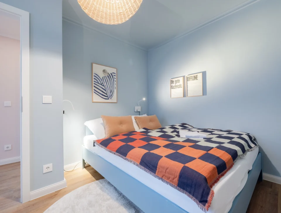 Kleines Schlafzimmer in einem Hamburger Apartment mit Farbkonzept in sanften Beige- und Blautönen